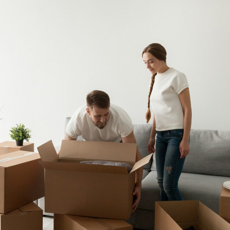 young-spouses-carrying-boxes-relocating-new-flat_1163-4144